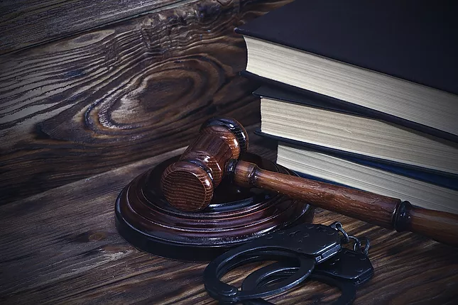 Image of law books, handcuffs and a judges gavel