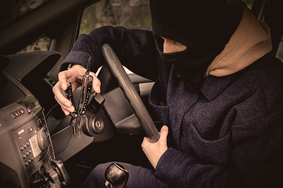 A Car Thief Is Trying To Open The Ignition Lock With A Tool.
